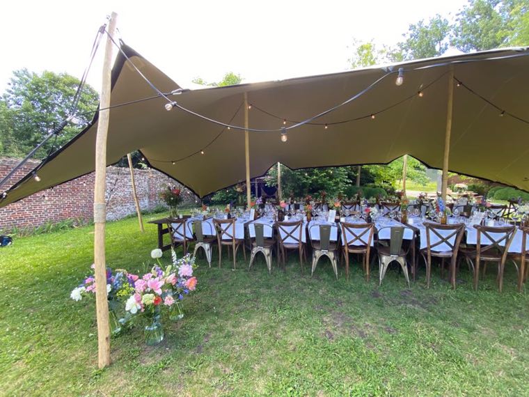 Gezelschap aan lange tafels in de tuin