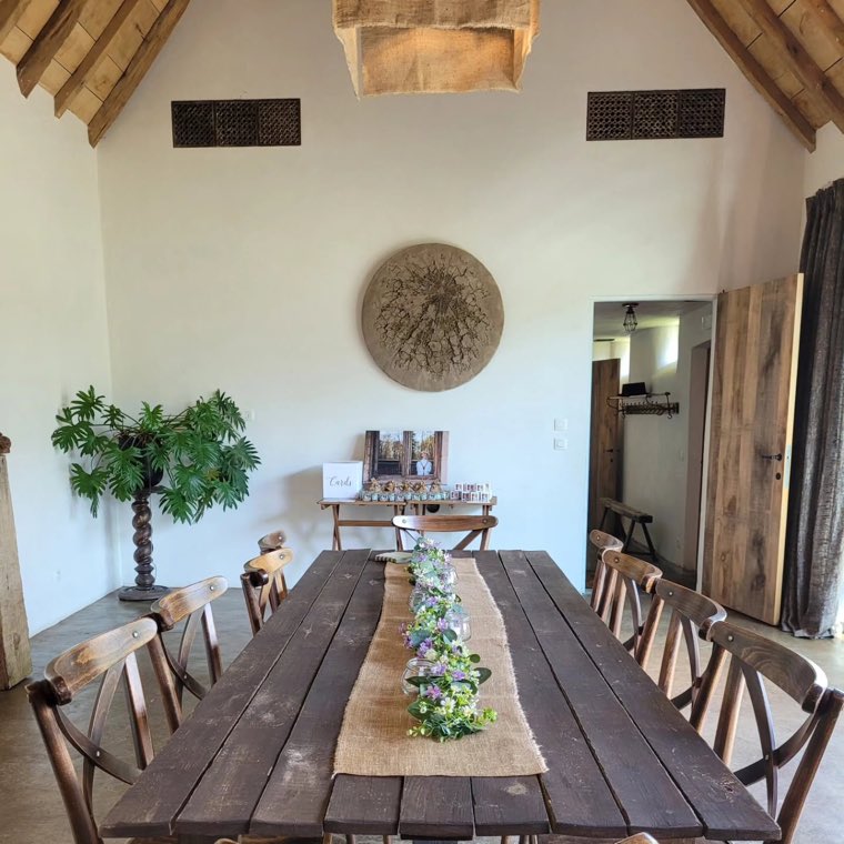Eén lange houten tafel onder de dakbalken