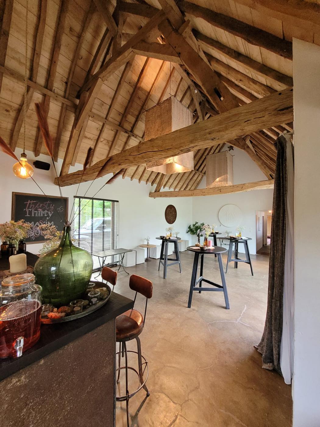 De Grote zaal met open eiken gebinte, bar en statafels